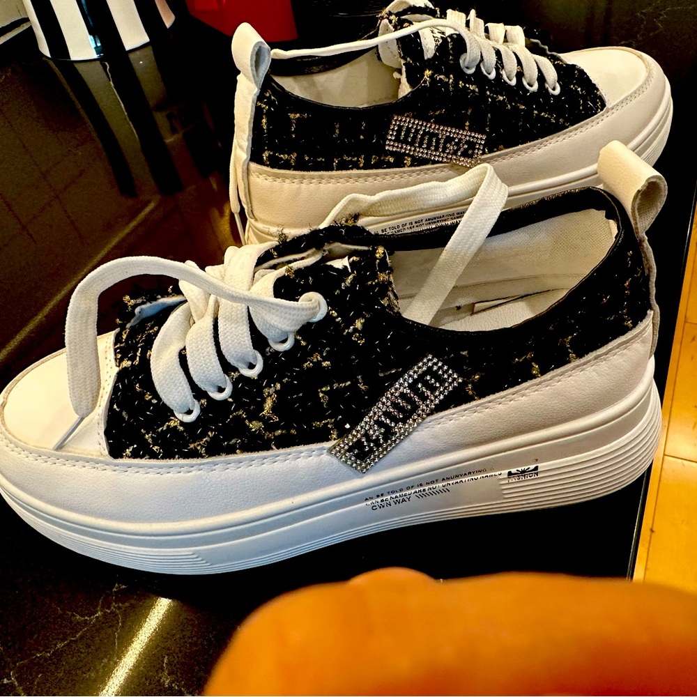 belbe black, gold, and white sneakers.